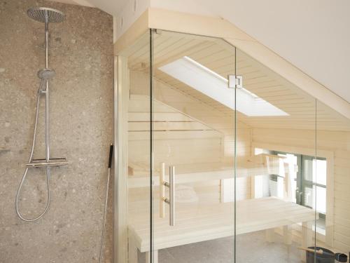 a glass shower in a bathroom with a staircase at OSTKÜSTE - Villa Steigel Design Apartments in Ahlbeck