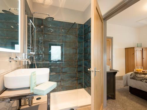 een badkamer met een wastafel en een douche bij Moorgate Cottage in Kelbrook