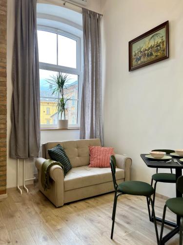 sala de estar con sofá y ventana en The Lovely Loft, en Liubliana