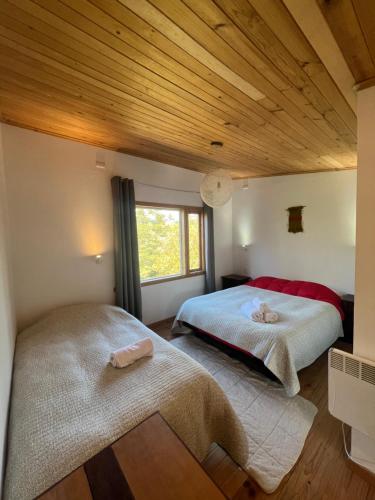 2 camas en un dormitorio con techo de madera en Hamilton's Place Bed and Breakfast, en La Ensenada