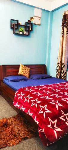 a bedroom with a bed with a red comforter at Mirik Homestay in Mirik
