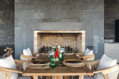 a dining room table with chairs and a fireplace at Ngorongoro Lodge member of Melia Collection - The Leading Hotels of the World in Ngorongoro