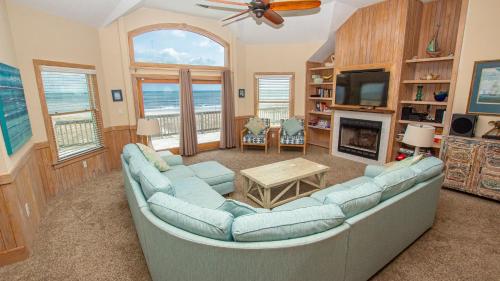 a living room with a large couch and a television at Oceanfront, Wild Horses, Ocean Views, Private Pool, 4x2251, Beauty & The Beach in Knotts Island