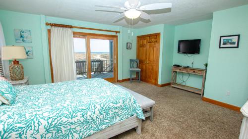 a bedroom with a bed and a flat screen tv at Oceanfront, Wild Horses, Ocean Views, Private Pool, 4x2251, Beauty & The Beach in Knotts Island