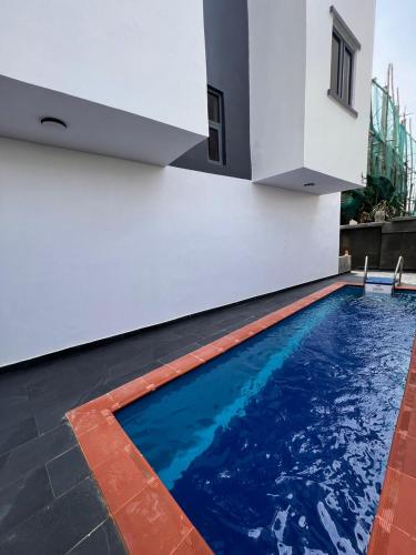 a swimming pool in the side of a house at Luxury Studio Flat With Pool at Kingsland Lekki in Igboefon