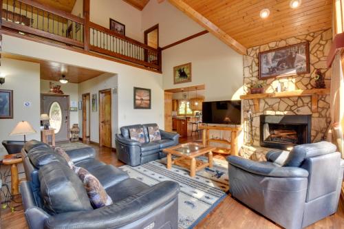 a living room with leather furniture and a stone fireplace at Hot Tub, Game Tables and Mtn Views Ellijay Cabin in Ellijay