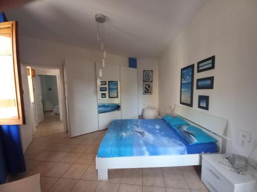 a bedroom with a bed with blue sheets and dolphin pillows at La Casa Rosada Arbus in Arbus