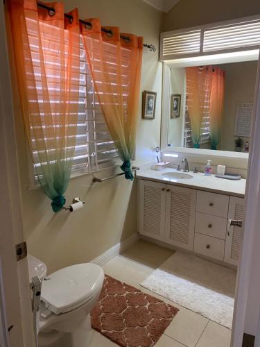 a bathroom with a toilet and a sink and a mirror at Island Style Villa in Richmond Estate Palms in Banks