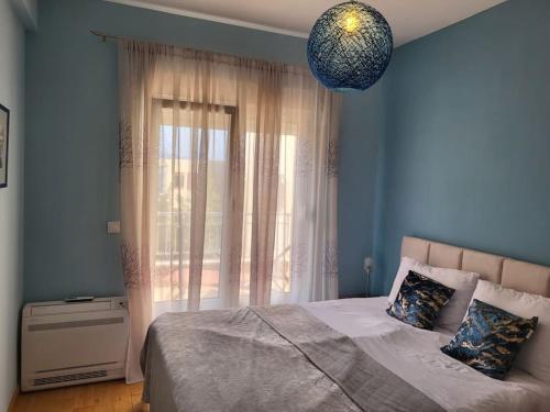 een slaapkamer met een bed en een groot raam bij Apartment Marina, two bedrooms in Tivat