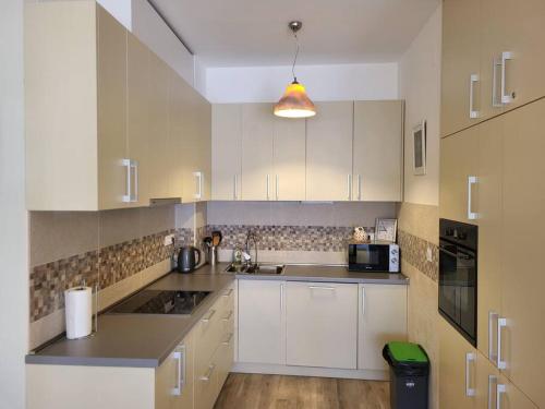een keuken met witte kasten en een zwarte magnetron bij Apartment Marina, two bedrooms in Tivat