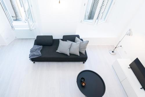 a living room with a black couch and a table at La Dimora Della Torretta in Cantù