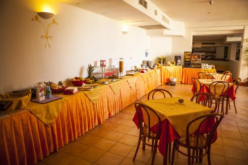 a long line of tables and chairs in a restaurant at Hotel Piccada in Palau