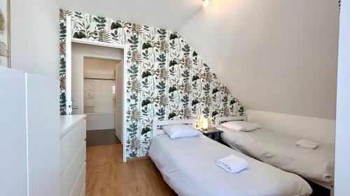 - 2 lits dans une petite chambre avec un miroir dans l'établissement Ma cabane de plage, à Saint-Valery-sur-Somme
