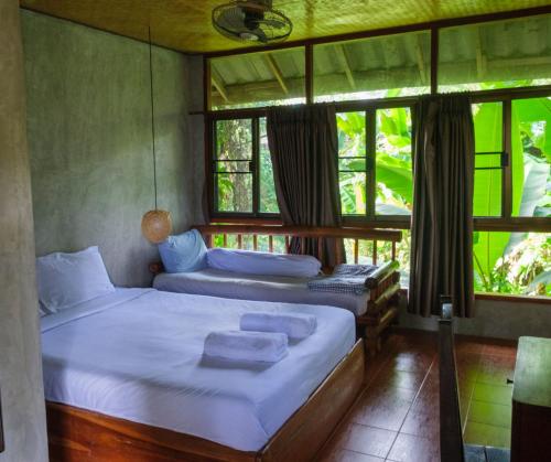 una camera da letto con due letti e una finestra di Shaya Resort a Pai