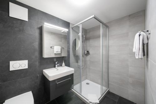uma casa de banho com um chuveiro, um lavatório e um WC. em Studio ALBERT Interlaken em Interlaken
