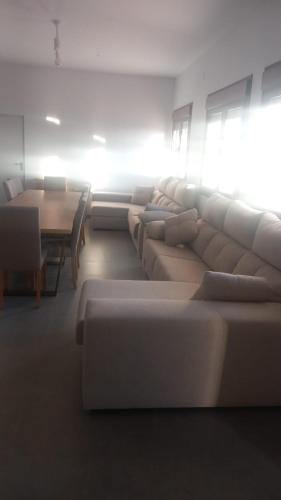 a living room with couches and a dining room with a table at Casa La Cruz Pintá in Murtas