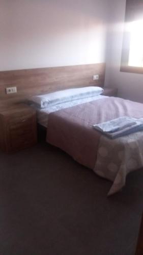 a bedroom with two beds and a wooden headboard at Casa La Cruz Pintá in Murtas