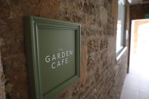 a green picture frame hanging on a brick wall at Holbrook Manor & Spa in Wincanton