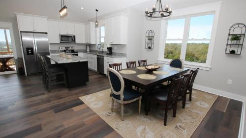 a kitchen and dining room with a table and chairs at Semi-Oceanfront, Ocean Views, Wild Horses, Private Pool, 4x2338, Race To The Beach in Knotts Island