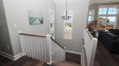 a living room with a staircase with a couch at Semi-Oceanfront, Ocean Views, Wild Horses, Private Pool, 4x2338, Race To The Beach in Knotts Island