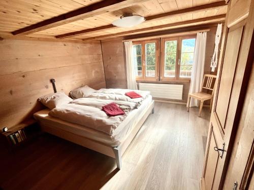 una camera da letto con letto in una camera in legno di Chalet Sonnenheim, Wohnung mit Panoramafenster ad Adelboden