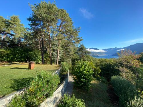 a garden with a view of the water and mountains at Studio - Villa Cardano in Como