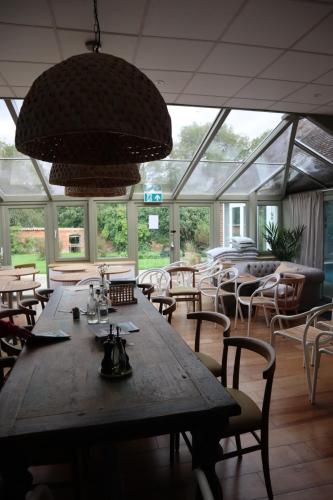 a dining room with a large wooden table and chairs at Holbrook Manor & Spa in Wincanton