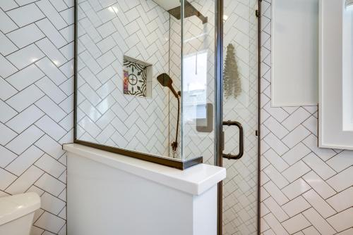 y baño con ducha con espejo sobre un lavabo. en Renovated Seaside Park Cottage Steps to Beach!, en Seaside Park
