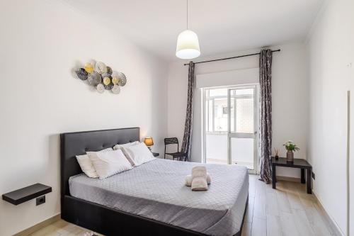 ein Schlafzimmer mit einem großen Bett und einem Fenster in der Unterkunft Sleeptubal Moderne Accommodatie in Alhos Vedros