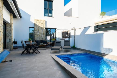 a patio with a swimming pool next to a building at Moderna Casa VillaCristal in Daya Vieja