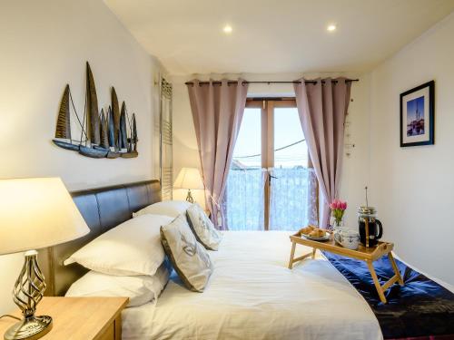 1 dormitorio con 1 cama con mesa y ventana en Crows Nest en Wells next the Sea