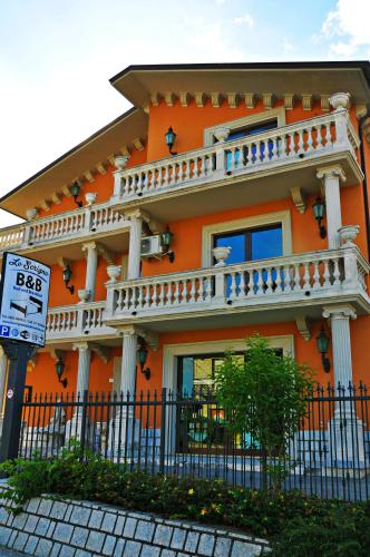 Una casa de color naranja con balcón en la parte superior. en Lo Scrigno B&B, en Montemiletto