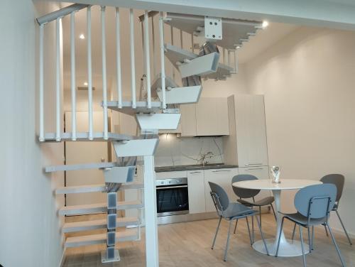 uma escada em espiral numa cozinha com uma mesa e cadeiras em LLHOME BOLOGNA Elegante monolocale ristrutturato con posto auto coperto em Bolonha