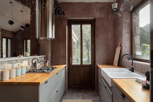 a kitchen with a sink and a stove top oven at Hidden Stone Chalet in Zarouchla