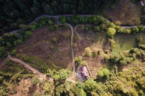 an aerial view of a forest with a house and a road at Hidden Stone Chalet in Zarouhla