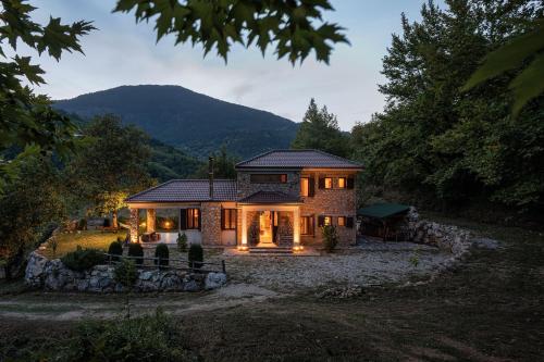 a house with lights on inside of it at Hidden Stone Chalet in Zarouhla