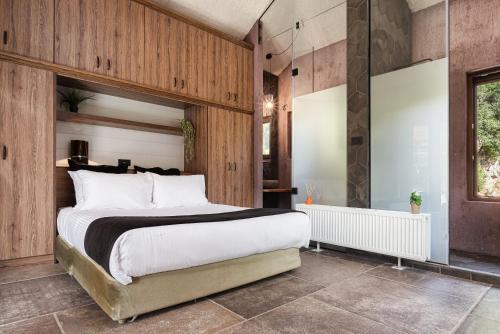 a bedroom with a large bed and wooden walls at Hidden Stone Chalet in Zarouhla