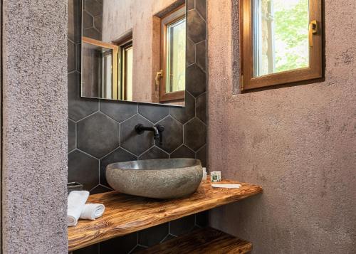a bathroom with a stone sink and a mirror at Hidden Stone Chalet in Zarouhla