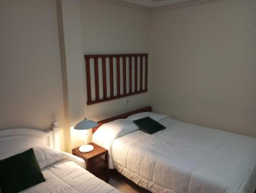 1 dormitorio con 2 camas y una lámpara en una mesa en Mini suite, en Loja