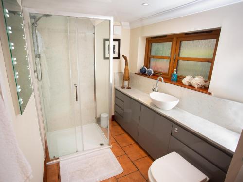 a bathroom with a shower and a sink at Craigellachie Cottage in Croy