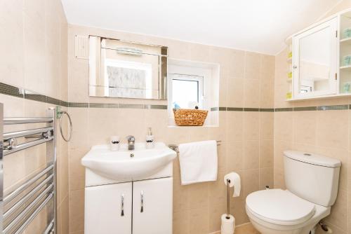 y baño con aseo y lavamanos. en King Room with a shared Kitchen and bathroom in a 5-Bedroom House at Hanwell en Hanwell
