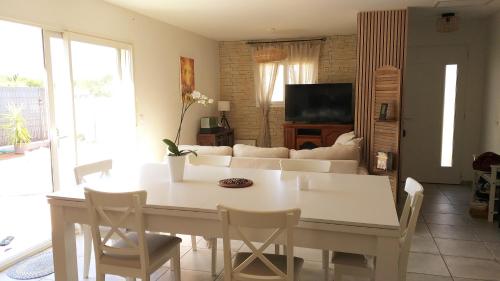 sala de estar con mesa blanca y sofá en Chambre dans maison, près de la mer, de l'Espagne, des Montagnes en Pézilla-la-Rivière