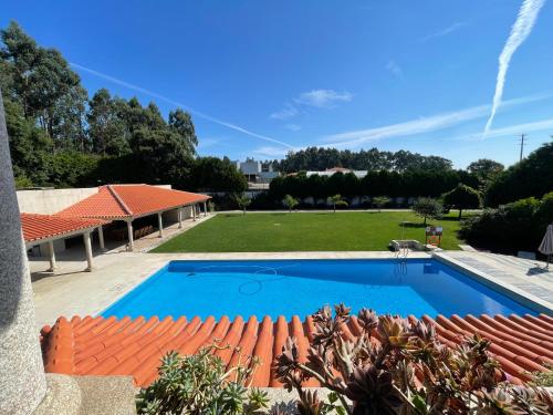 a large swimming pool in a yard with a garden at Casa de Lamaçais in Vilela