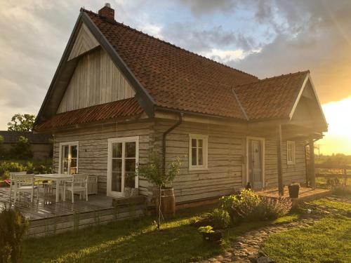 ein Holzhaus mit einer Terrasse und einem Tisch in der Unterkunft Dom z Bieszczad na Kaszubach - całoroczny dom z balią ogrodową in Kowalewo