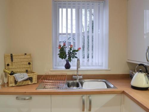 a kitchen counter with a sink and a window at Red House in Torquay