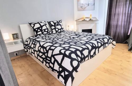 - un lit noir et blanc dans une chambre avec cheminée dans l'établissement LE BARBUSSE Coeur de Ville Superbe Déco Climatisé, à Sète