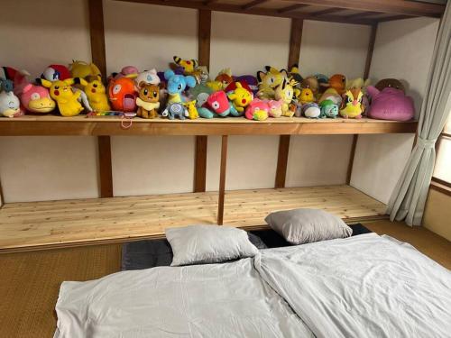 a shelf with a bunch of stuffed animals on it at 窓から海の見える静かな貸切一軒家 Dragon Sea Side House BBQ可 in Minamichita
