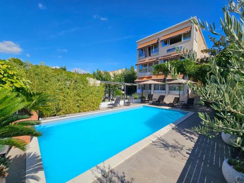 an image of a swimming pool in front of a house at Apartments Marina in Šibenik