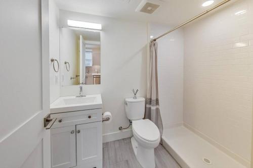 Baño blanco con aseo y lavamanos en Entire Furnished Luxury Apt in Lake Merritt en Oakland