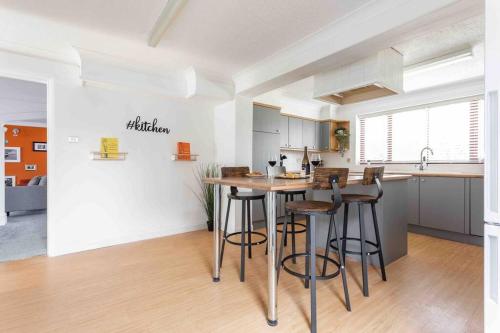 een keuken met een tafel en stoelen in een kamer bij The Orange House Langdon Hills 